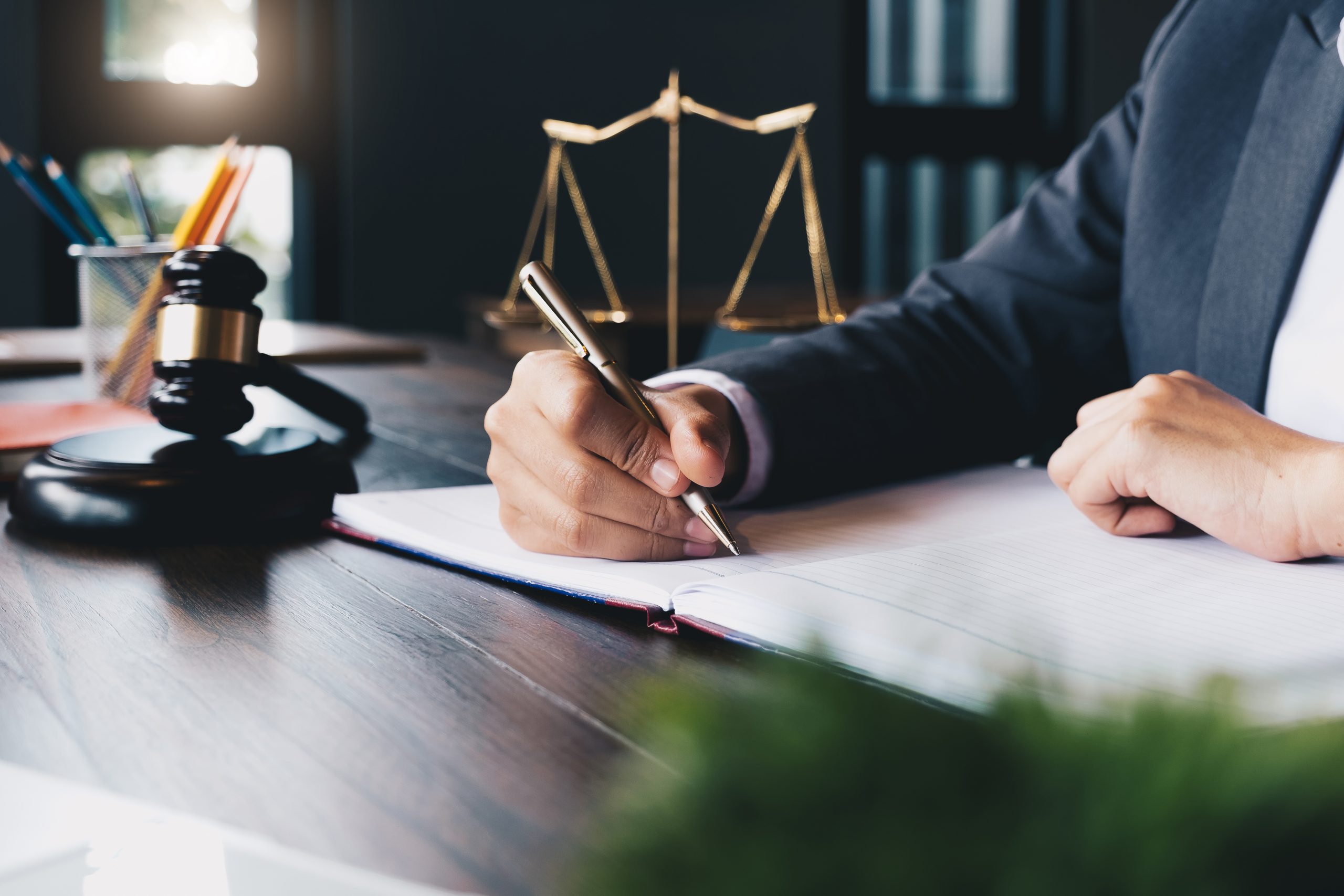 Lawyer sitting at his desk, writing in a notebook